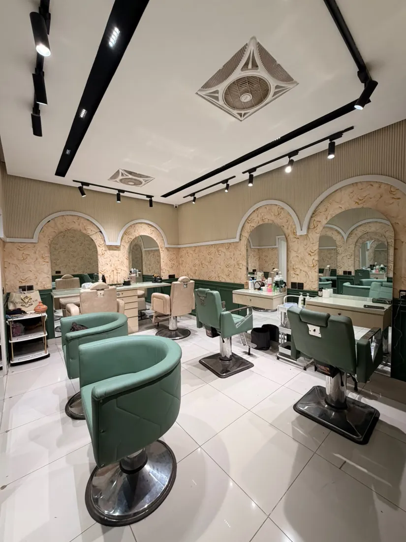 Makeup room with arched mirrors and green chairs